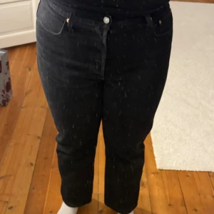 Svarta Levis 501 90’s jeans W33 L30 - Säljer ett par svarta Levis 501 jeans med klassisk knappgylf och raka ben. Jeansen har fem fickor, hög midja och är tillverkade i kraftig bomullsdenim. Perfekta för dig som gillar en tidlös och clean look.