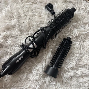 Babyliss varmluftsborste  med två borsthuvuden - Elektrisk rundborste från Babyliss i svart med två utbytbara borsthuvuden. Perfekt för att styla och ge volym till håret. Borsthuvudena är runda och har täta svarta borststrån och piggar för enkel styling. Sladd medföljer och allt är i stilren design. Säljer då ja redan har en