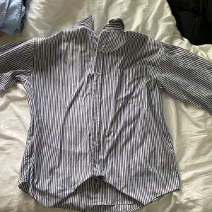 Randig skjorta från Diplom Classic - Snygg skjorta från Diplom Classic i vitt och blått med klassiskt randigt mönster. Skjortan har lång ärm, bröstficka och knäppning framtill. Perfekt för dig som gillar en stilren och tidlös look.