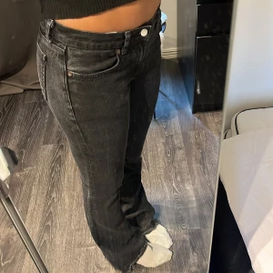 Svarta bootcut jeans från Zara - Säljer ett par svarta jeans från Zara i bootcut-modell med råa kanter nertill. Jeansen har låg midja, klassiska fem fickor och är tillverkade i ett stretchigt denimtyg. Perfekta för dig som gillar en avslappnad men trendig look.Jag har sprättat upp byxorna, se sista bild: