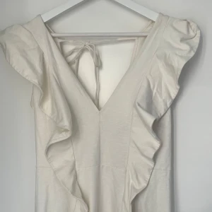 Vit Strandklänning - Säljer denna off-vita klänningen som är perfekt att ha på sig till stranden, den är i lite tjockare material. Köpte den från Sellpy men den var tyvärr i fel storlek. Når ner till mitten av låren.