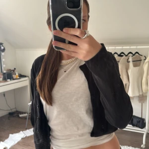 Svart ribbad kofta från Zara - Säljer en svart ribbad kofta från Zara i storlek M. Den är ganska kort, och har knappar framtill. Perfekt att slänga över en t-shirt för en chill och stilren look. Materialet är mjukt och stretchigt, vilket gör den superbekväm att bära.🩶🩵💞