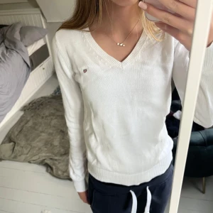 Vit stickad tröja från GANT - säljer en klassisk vit stickad tröja från GANT i storlek XS. tröjan har v-ringning, ribbade muddar och en liten broderad logga på bröstet. superenkel att matcha med allt! skriv vid fler frågor!!💓
