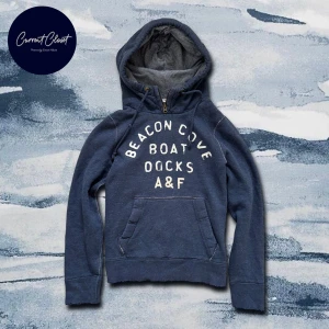 Blå hoodie från Abercrombie & Fitch - Mysig marinblå hoodie från Abercrombie & Fitch med broderad text på bröstet | Size S | Defekter förekommer då denna är vintage | Obs… texten är vit men ljuset gör att den ser gul ut