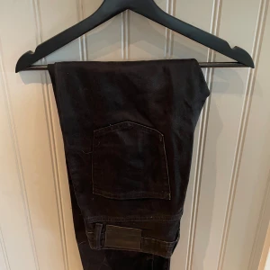 Svarta jeansbyxor från 157, stl S - Svarta jeansbyxor från 157 i storlek S. Klassisk femficksmodell med raka ben och enkel design. Byxorna är tillverkade i ett slitstarkt jeanstyg och har en diskret svart patch bak i midjan. Perfekta till en avslappnad streetstil.