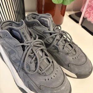 Grå adidas sneakers  - Snygga grå sneakers från adidas med chunky sula och coola detaljer i mocka och textil. Perfekta för dig som gillar streetstyle och vill ha bekväma skor med stil. Nypris 1600kr
