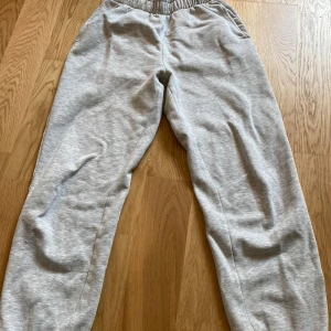 Grå mjukisbyxor från Gina Tricot - Superbekväma grå mjukisbyxor från Gina Tricot, basically basics-kollektionen. De har resår i midjan och är gjorda i mjuk bomullsmix. Perfekta för chill dagar eller när du vill ha en avslappnad stil.