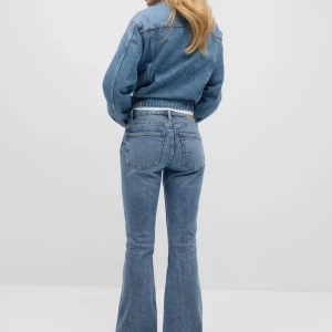 Blå bootcut jeans med låg midja - Snygga blå jeans med bootcut-modell och låg midja. Jeansen har klassisk femficksdesign och är tillverkade i ett mjukt denimtyg. Perfekta för dig som vill ha en retrovibe och markerad siluett.
