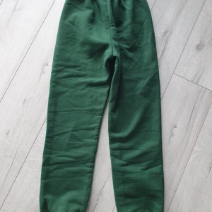 Mörkgröna fleecebyxor med resår - Mörkgröna mjukisbyxor i fleece med resår i midjan. Perfekta för chill dagar eller när du vill vara extra bekväm. Raka ben och enkel design utan detaljer.