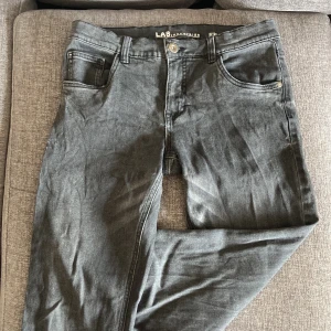 Grå jeans från LAB Industries - Snygga grå jeans från LAB Industries i regular fit med klassisk femficksdesign. Jeansen har en rak passform och är tillverkade i ett mjukt bomullsmaterial med lite stretch. Perfekta för dig som gillar en enkel och stilren look.