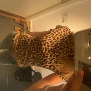 Leopardmönstrad topp från H&M XS - Säljer en snygg leopardmönstrad topp från H&M i storlek XS. Toppen har korta ärmar, hög hals och är figurnära i modellen. Perfekt för dig som vill sticka ut med ett djurmönster. Den är i mkt bra skick! 