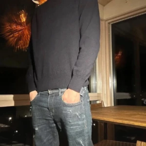 Svart kashmirtröja från Oscar Jacobson - Säljer en svart, klassisk kashmirtröja från Oscar Jacobson. Tröjan har rund halsringning, ribbade muddar och en clean look som funkar till allt. Perfekt för dig som gillar stilrena och mjuka plagg. Made in Italy.