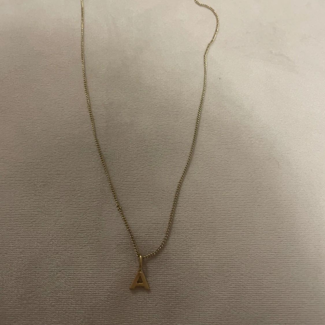 Guldigt halsband med bokstav A från Pilgrim