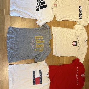 Gant T-shirt - Säljer ett paket med sex snygga t-shirts från Adidas, Gant och Tommy Hilfiger. Färgerna är vitt, grått och rött med tryck och loggor på bröstet. Alla är klassiskt kortärmade och gjorda i mjuk bomull, perfekta för chill och streetwear. Passformen är normal och de har en modern vibe. Är storlek xs till S  men passar mer S. 329 kr för alla eller 70kr styck. Skicka dm om fler bilder.