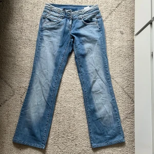 Lågmidjade jeans - Lågmidjade bootcutjeans från vero Moda med detaljer på bakfickan.