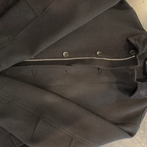 Svart bomberjacka från Zara! Helt ny!  - Snygg svart bomberjacka från Zara med cool manchesterkrage och både dragkedja och knappar framtill. Den har en cropped look med raka fickor och en stilren look som passar perfekt till höst och vinter. Materialet känns mjukt och värmande. Som sagt är den helt ny och verkligen fräsch! Storleken är S men passar definitivt M också! 