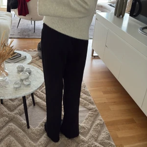 Svarta mjukisbyxor med snörning - Svarta mjukisbyxor med rak passform och snörning i midjan. Byxorna har en avslappnad look och är perfekta för chill dagar. Materialet känns mjukt och bekvämt mot huden.