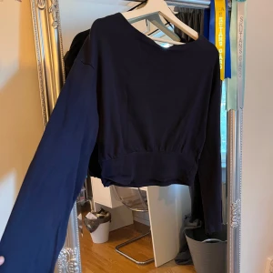 Mörkblå croppad tröja Gina Tricot - Säljer en mörkblå croppad tröja från Gina Tricot. Tröjan har lång ärm, bred mudd nertill och är tillverkad i ett mjukt bomullstyg. Enkel och stilren modell som är lätt att matcha med jeans eller kjol. Super söt att ha ett vitt linne under med ett par jeans!💕