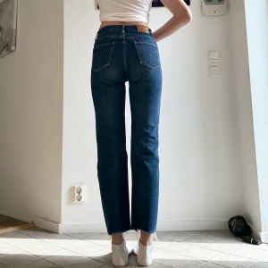 mörkblå raka Calvin Kleinjeans  - Mörkblå Calvin Klein jeans med medelhög midja och raka ben. Klassisk femficksmodell i jeansmaterial med rå, fransad fåll nertill. De har tyvärr blivit för små på mig som är 173 cm lång. De brukade vara mina favoritjeans när längden och bredden fortfarande passade mig:(