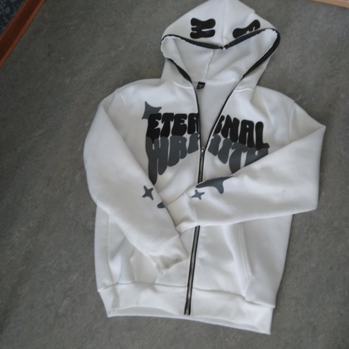 Vit hoodie med svart tryck och dragkedja