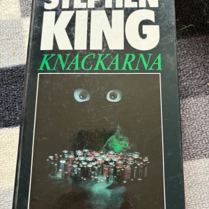 Knackarna - En mystisk och spännande bok där något okänt lurar under ytan. Perfekt för dig som gillar skräck och oväntade händelser. En berättelse om det främmande i vardagen som garanterat får dig att vilja läsa vidare – vågar du öppna dörren för Knackarna?