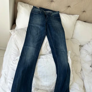 Lee Bonnie blå jeans W27 L33 - Snygga blå jeans från Lee i modellen Bonnie. Klassisk femficksdesign med Lee-logga på bakfickan och kontrastsömmar. Jeansen har rak passform och normal midja, tillverkade i slitstarkt bomullsmaterial. Perfekta för dig som gillar en tidlös och chill stil.