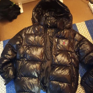 Svart dunjacka från Polo Ralph Lauren - Säljer en svart, glansig dunjacka från Polo Ralph Lauren storlek S då den är lite för stor för mig. Priset kan sänkas skriv om du är intresserad 