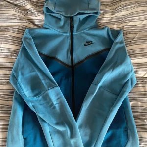 Nike tech blå - Säljer min nike tech fleece då jag inte använder den längre, köpt från jd sport ett tag sedan, använd max 10 gånger, har tagit hand om den som om den vore mitt barn. Kan tänka mig byta med under armour eller annat. Kom med förslag. Pris går att diskuteras