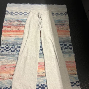 Ljusgrå mjukisbyxor från Gina Tricot - Superbekväma ljusgrå mjukisbyxor från Gina Tricot i storlek XS. Byxorna har breda ben, dragsko i midjan och är gjorda i mjukt bomullsmaterial. Perfekta för chill dagar eller när du vill vara extra comfy.