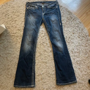 True religion jeans - Jätte fina mörkblåa true religion jeans som är köpta på en vintage affär i Australien. Köpta för 900. Säljer då de inte kommer till användning. De står storlek 30 på dem vilket jag inte vet vad de motsvarar men jag skulle säga kanske 36-38. Jeansen sitter bra i längd för mig som är 165 cm lång. Skriv gärna vid funderingar och prisförslag. Jag kan även tänka mig att byta dessa mot några andra jeans med ungefär samma värde.