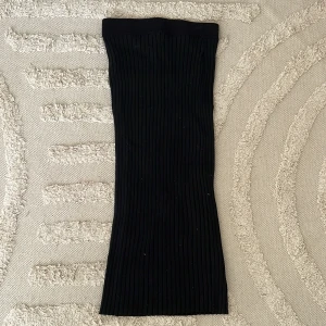 Svart ribbad kjol från Lindex - Svart ribbad kjol från Lindex i storlek XS. Kjolen är rak och har en elastisk midja för skön passform. Materialet är mjukt och stretchigt, perfekt för dig som gillar enkel och stilren look. 