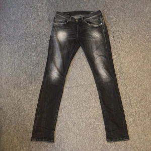 Svarta skinny jeans i tvättad look - Säljer ett par svarta skinny jeans med snyggt tvättad effekt och slitningar på låren. Anledningen till att jag säljer dem så billigt är på grund av att dem har en liten skada på sömmen på vänstra benet. Se bild nummer 4