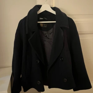 Mörkblå kappa från Zara - Säljer en mörkblå kappa från Zara med dubbelknäppning och bred krage. Perfekt för höst och vinter när du vill vara både varm och snygg🍂💞