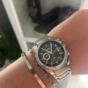 Casio silverfärgad klocka  - Stilren Casio kronografklocka i silver med svart urtavla och detaljer i vitt och gult. 