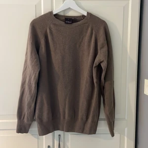 Beige stickad tröja Oscar Jacobson - Snygg beige stickad tröja från Oscar Jacobson, tillverkad i Italien. Tröjan har rund hals, ribbade muddar och diskret OJ-broderi vid nederkanten. Perfekt för dig som gillar stilrena och klassiska plagg med en soft vibe. Nypris 1400kr. Priset går att diskuteras. Storleken passar både M och S 