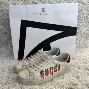 Gucci ace skor - Tja säljer nu ett par  Gucci ace skor i storlek  42 där det står GUCCI med en unik design i rött och grönt på sidan som är svåra att få tag på, inga defekter förutom lite slitage av användning på hela skorna men inget som påverkar skorna, men annars 10/10. Ny pris 9.000, Inget OG följer med!! Skriv om du har några frågor och va inte rädd att lägg bud!!! Kolla måtten innan du köper om du är osäker!!  Byten funkar mot andra skor det är bara att skriva isåfall!!!!