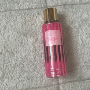 Victoria's Secret Bombshell New York - En snygg parfymmist från Victoria's Secret, Bombshell New York. Flaskan är cylinderformad i genomskinlig rosa plast med svarta ränder och har ett glansigt guldlock. Rymmer 250 ml och har en fräsch, feminin doft med shimmer-effekt. Använd endast 2 gånger det finns inte o köpa eftersom köpte den för 2 år sedan 