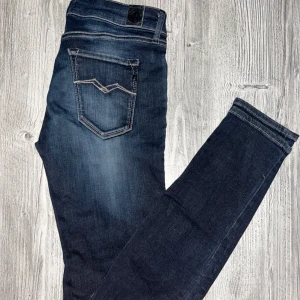 Replay mörkblå  jeans - Snygga mörkblå jeans från Replay. Jeansen har klassisk femficksdesign, ljusa slitningar och kontrastsömmar. Märkesdetaljer på linning och ficka. Perfekta för dig som gillar en modern look.
