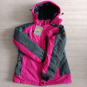 Rosa och grå vinterjacka från Gemysé - Snygg vinterjacka från Gemysé i rosa och grått med huva och mjukt foder. Jackan har dragkedja, flera fickor och quiltade detaljer på insidan. Perfekt för kalla dagar och har en sportig look med kontrastfärger.