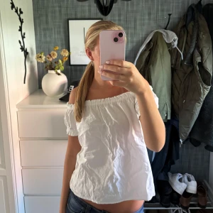 Vit offshoulder blus - Säljer en söt vit offshoulder blus med korta puffärmar och resår vid axlarna. Perfekt för varma dagar och ger en avslappnad men ändå trendig look. Lätt och luftig känsla, passar till både jeans och kjol.