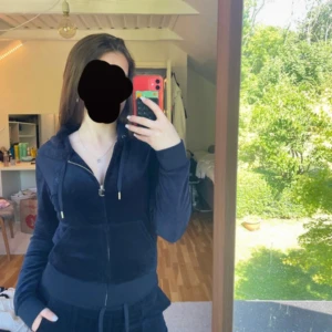 Mörkblått juciy coutoure sett - Juicy Couture sett i mörkblått med dragkedja och huva. Klassisk modell med snörning i huvan, ribbade muddar och fickor framtill. Perfekt för en chill och trendig look.