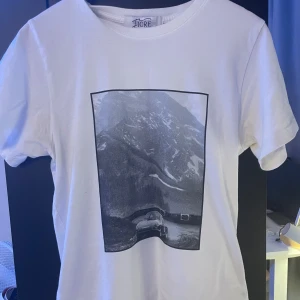 Fiore studios T-shirt med motiv - Vit T-shirt från fiore studios med snyggt motiv, i storlek S. Kom med bud!