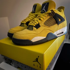 Gula Nike Air Jordans 4 - Snygga gula Nike Air Jordans med svart och vit detaljering. Skorna har en rund tå och snörning framtill. Perfekta för att sticka ut med sin djärva färg och ikoniska design. Storlek 45 använda endast 5 gånger, kan säljas för vilket pris som helst vill bli av med dom så fort som möjligt, skriv om det finns några funderingar 