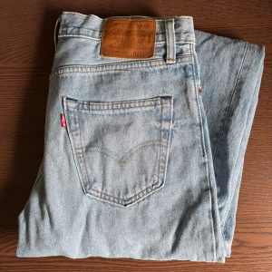 Levi's jeans i ljusblå denim - Loose Levi's jeans i ljusblå denim. De har en bred passform och är tillverkade i slitstarkt jeanstyg. Perfekta för en avslappnad stil. Märkeslappen i läder sitter på baksidan. Storlek W29 L32. Se sista bild för passform.