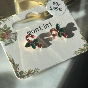 Julörhängen från Montini - Söta örhängen i form av polkagrisar med gröna blad från Montini. Perfekta för att ge en festlig touch till din juloutfit. Helt oanvända🤍