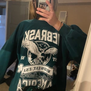 Grön oversized sweatshirt med tryck - Säljer en mörkgrön oversized sweatshirt med tryck. Tröjan är i s men skulle säga att den passar xs-m för en oversized look🫶🏼