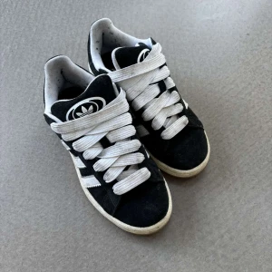 Svarta adidas campus - Snygga och sköna svarta sneakers med vita detaljer och breda snören från Adidas. Använda men i bra skick.