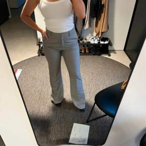 Helt oanvända grå kostymbyxor från Mango i storlek 40. Flare modell och långa i benen. Ordinarie pris är 599kr.