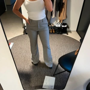 Grå kostymbyxor - Helt oanvända grå kostymbyxor från Mango i storlek 40. Flare modell och långa i benen. Ordinarie pris är 599kr.