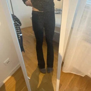 Svarta ribbade byxor - Säljer ett par svarta ribbade byxor med en tight passform. Byxorna är mid waist (man kan vika ner de så att det blir lågmidjade )och har en stilren design som passar perfekt för en trendig look.